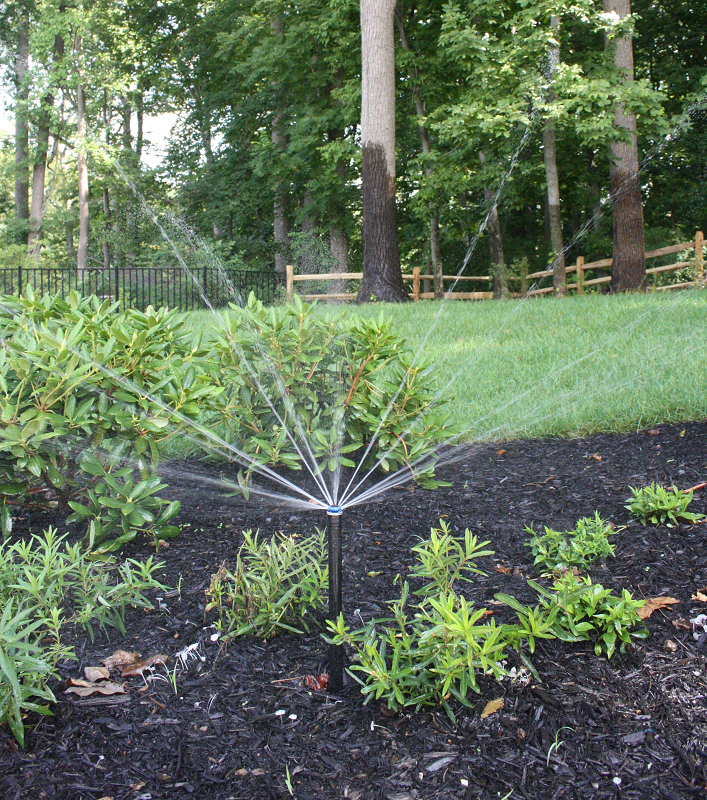 Flower bed with sprinkler irrigation system running | soil management | Burkholder Brothers