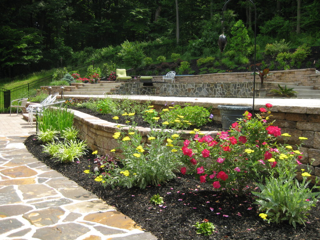 Flower bed with stone walls along walkway | plant health care | Burkholder Brothers